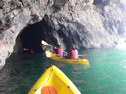 Twee mensen die een grot in kajakken tijdens de Kajaktocht in Salema door grotten met Salema Tours.