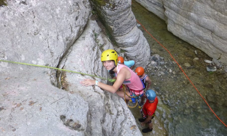 Kind die een rots beklimt tijdens Canyoning in de Nefeli Canyon voor families door Active Nature Epirus.