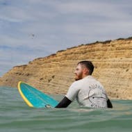 A surf instructor in the water during surf lessons in Lagos organized by Algarve Watersports.