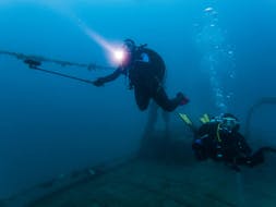 Zwei Taucher erkunden ein Schiffswrack während dem Wracktauchen in Banjole für zertifizierte Taucher organisiert von Diving Center Indie.