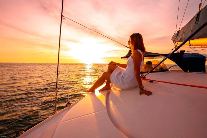 Woman with a white dress Enjoying the Sunset View in a Sailing Boat of BDA Experiences