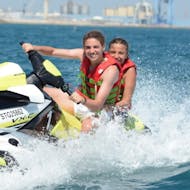 Two peopole smiling on a Jet Ski in Sète and Thau pond from Cap Caraibes Sète.