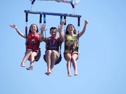 Three people during a Parasailing fly in Sète on Amethyst Coast from Cap Caraibes Sète.