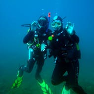 Unterwasseraufnahme von zwei Tauchern, die für die Kamera posieren, während eines geführten Tauchgängs in Albufeira für zertifizierte Taucher mit Indigo Divers Albufeira.