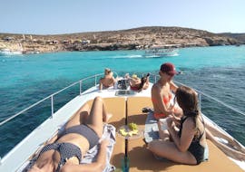 Menschen auf dem Boot von Bootstour in Comino zur Blauen Lagune mit Schwimmen von Mitzi Tours Malta entspannen sich und genießen ihre Snacks.