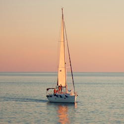 Ein Boot segelt auf dem Ozean während die Sonne untergeht während der Privaten Sonnenuntergangs-Bootstour von Malia nach Stalis & Hersonisos mit Abendessen organisiert von Malia Yachting.