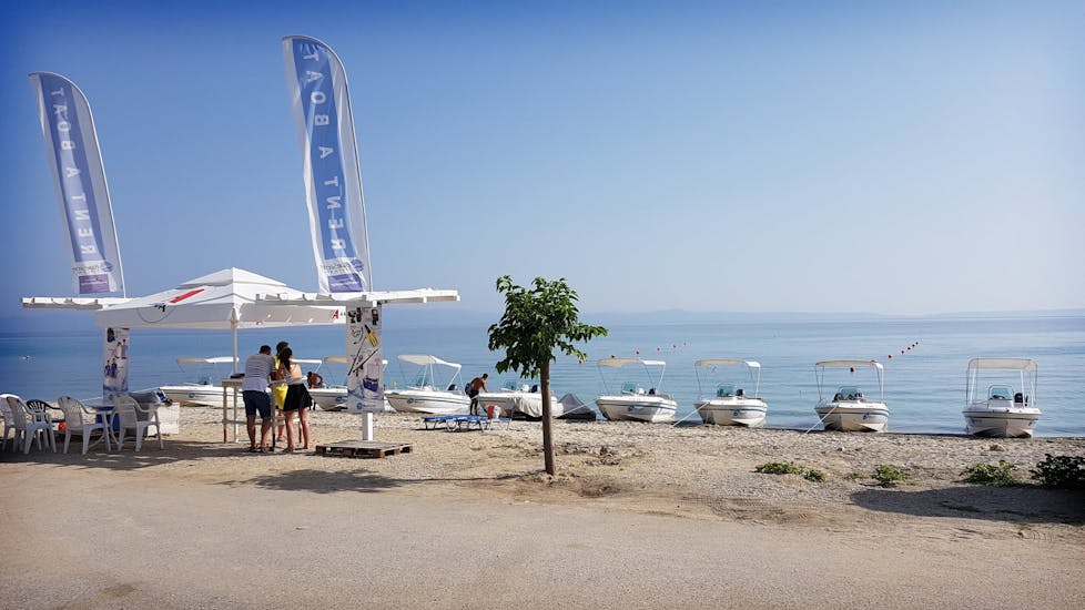 The beach with Blue Secret's stand and all their boats before the Boat Rental in Halkidiki (up to 6 people) without License.