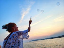 Eine Frau macht Seifenblasen während der Private Bootstour zum Sonnenuntergang auf Comino mit Mitzi Tours Malta.
