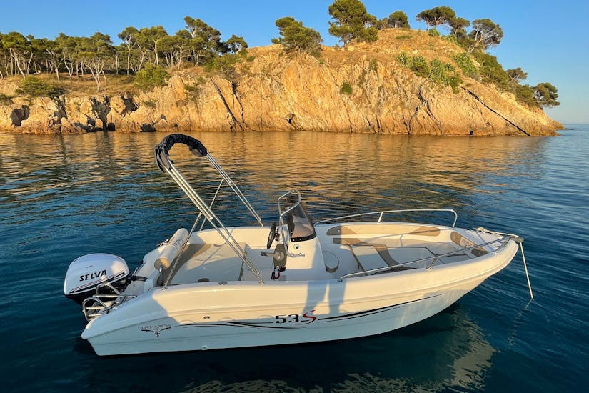 Boat Rental in Palamós with a serene sunset: boat, rocks, calm water without License (up to 6 people) from Palamós Boats.