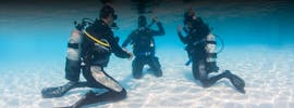Two people who are trying skills underwater under guidance of their instructor during the PADI Discover Scuba Diving Course in Halkidiki for Beginners from Triton Scuba Club Halkidiki.