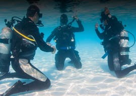 Two people who are trying skills underwater under guidance of their instructor during the PADI Discover Scuba Diving Course in Halkidiki for Beginners from Triton Scuba Club Halkidiki.