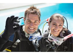 Two people who have all the diving gear on and are ready for their dive during the PADI Open Water Diver Course in Halkidiki for Beginners from Triton Scuba Club Halkidiki.