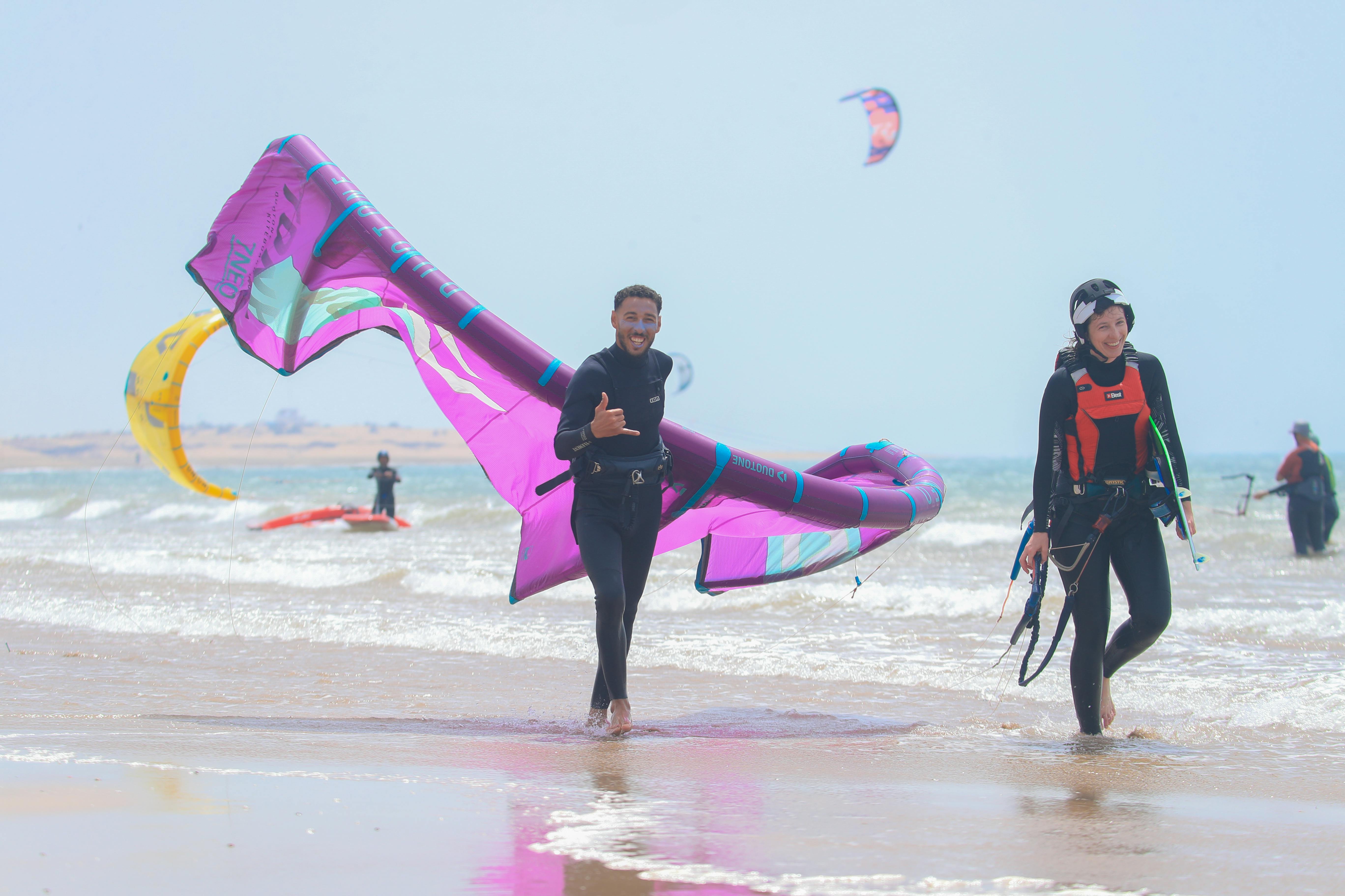 Person walking on the beach holding a kite during Semi Private Kitesurf Lessons (from 9 y.) on Plage d'Essaouira from Essaouira Watersports.