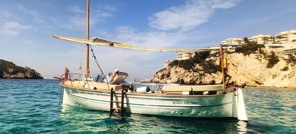 Tradicional Llaut Eléctrico de On Boat Mallorca Fondeado en una cala de mallorca