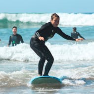 Ein Mädchen steht auf dem Surfboard auf einer Welle in Taghazout während dem Surfkurs (ab 5 J.) in Taghazout mit Taghazout Discovery.