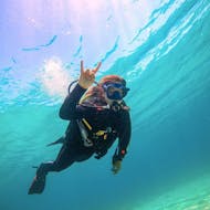 A girl doing the we rock sign underwater during the PADI Open Water Diver Course in Naxos for Beginners from Nima Diving Center Naxos.
