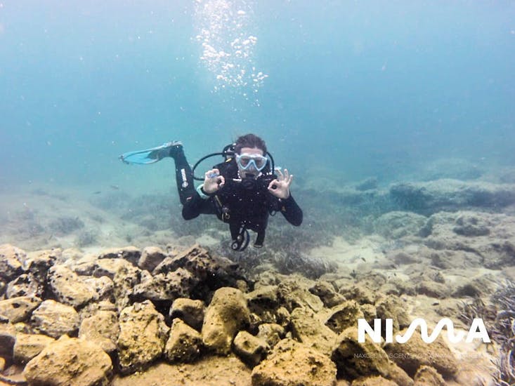 Een man die het okay teken maakt onderwater tijdens de PADI Open Water Diver Cursus in Naxos voor Beginners van Nima Diving Center.