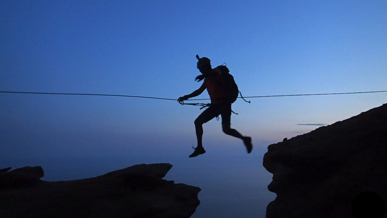 Man on a zip-line during ExpéNature Côte d'Azur's Dry Canyoning with Zip-lining in the Calanques National Park.