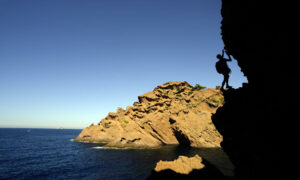 Man climbing during ExpéNature Côte d'Azur's Dry Canyoning with Zip-lining in the Calanques National Park.