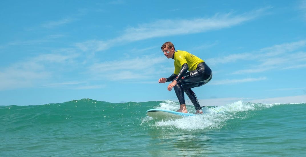 Un homme surfe une vague pendant son Cours de surf (dès 5 ans) sur la plage du Santocha à Capbreton avec Cactus Surf Capbreton.