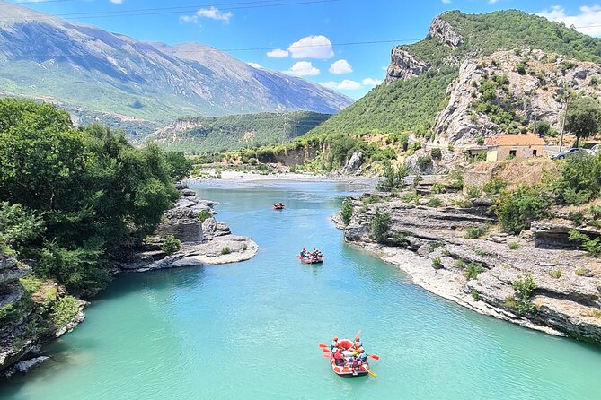 Der wunderschöne blaue Fluss Vjosa mit Leuten im Boot beim Rafting am Vjosa Wildfluss in Gjirokaster mit Vjosa Explorer Rafting Albania.