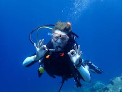 Een vrouw die het okay teken onderwater maakt tijdens de Discover Scuba Duiken voor beginners met Dive Club Kassandra.