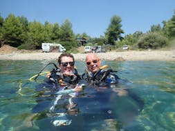 Two people in the water with their diving equipment during the PADI Scuba Diver Course in Kassandra for Beginners from Dive Club Kassandra.