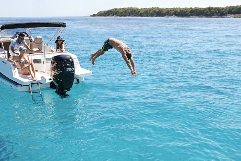 A man jumps into the ocean in our Boat Rental in Platja d'Aro with Licence (for up to 8 people).