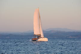 Un bateau navigue pendant la Balade en catamaran aux îles Lavezzi au coucher du soleil avec Baignade avec Voiles de Bonifacio.