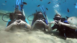 Three girls making a heart underwater during the Trial Scuba Diving in Crete for Beginners from Cretan Divers.