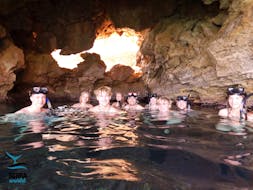 People in their snorkeling gear in a cave during the Snorkeling Trip in Agia Marina from Scuba World Agia Marina.