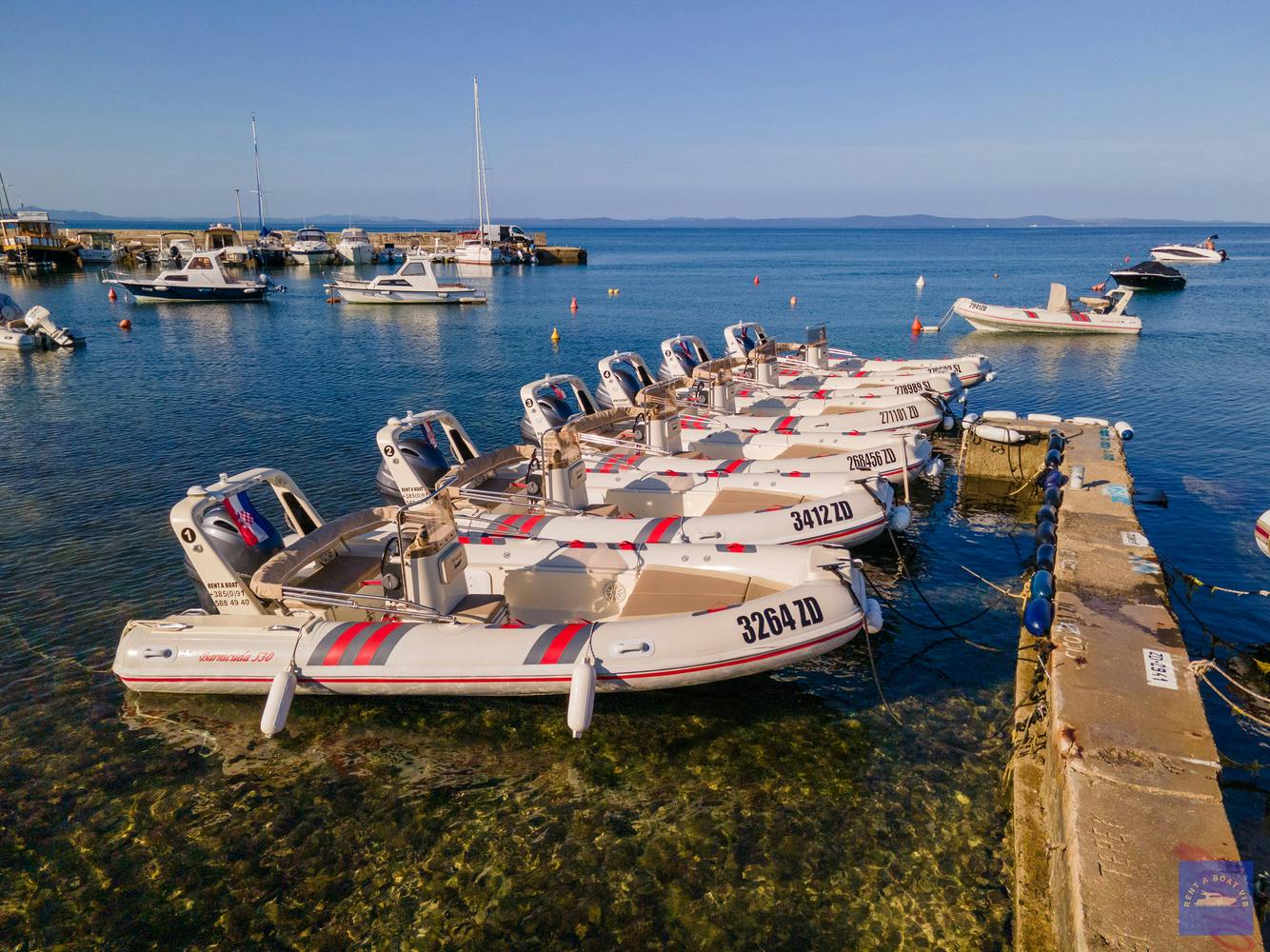 Multiple boats next to dock during Private Boat Trip to Island of Pag from Gizmo Rent a Boat Vir.