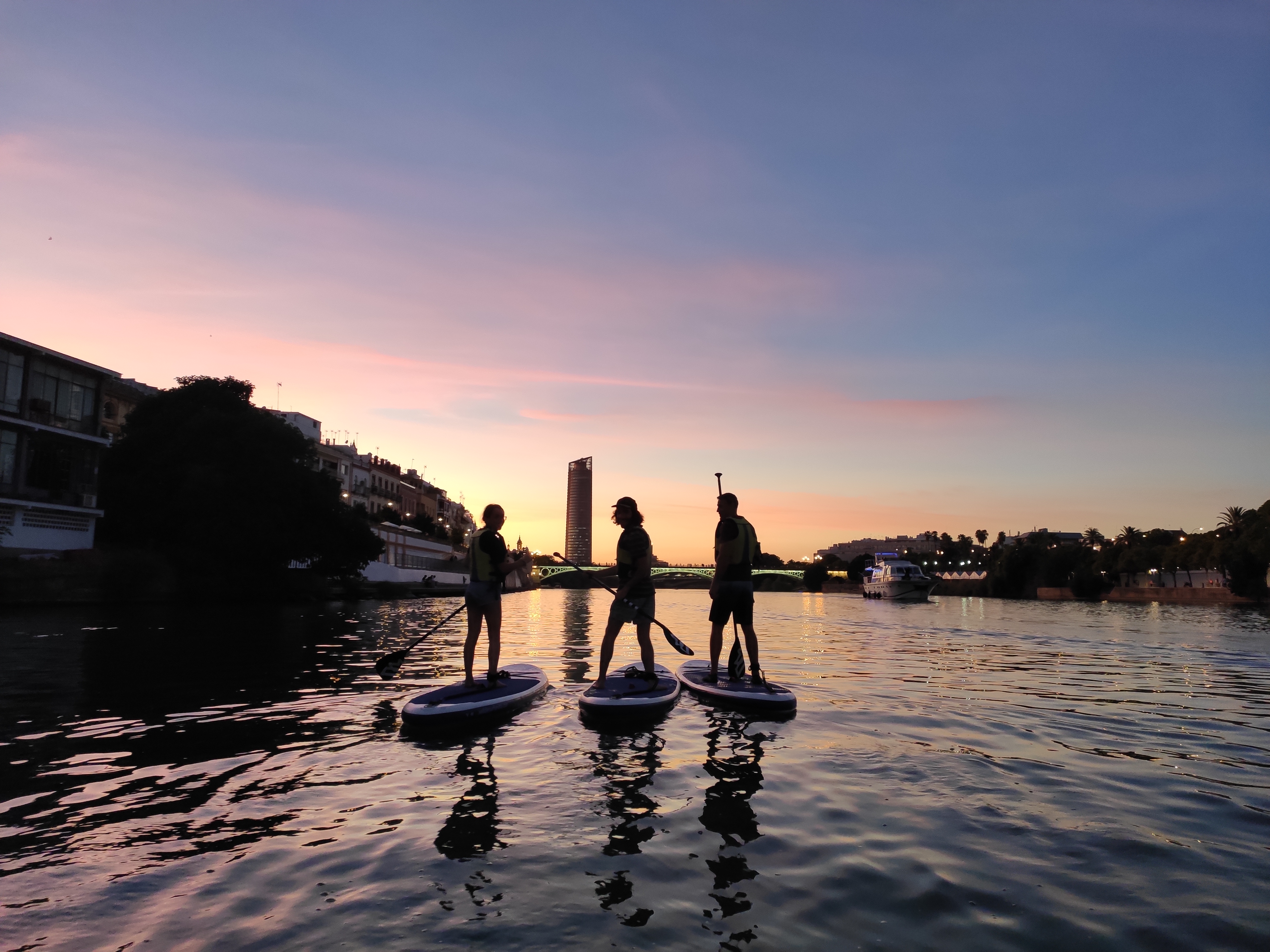 Geführte Stand Up Paddling Tour bei Sonnenuntergang entlang des Guadalquivir Flusses mit Paddle Surf Sevilla.