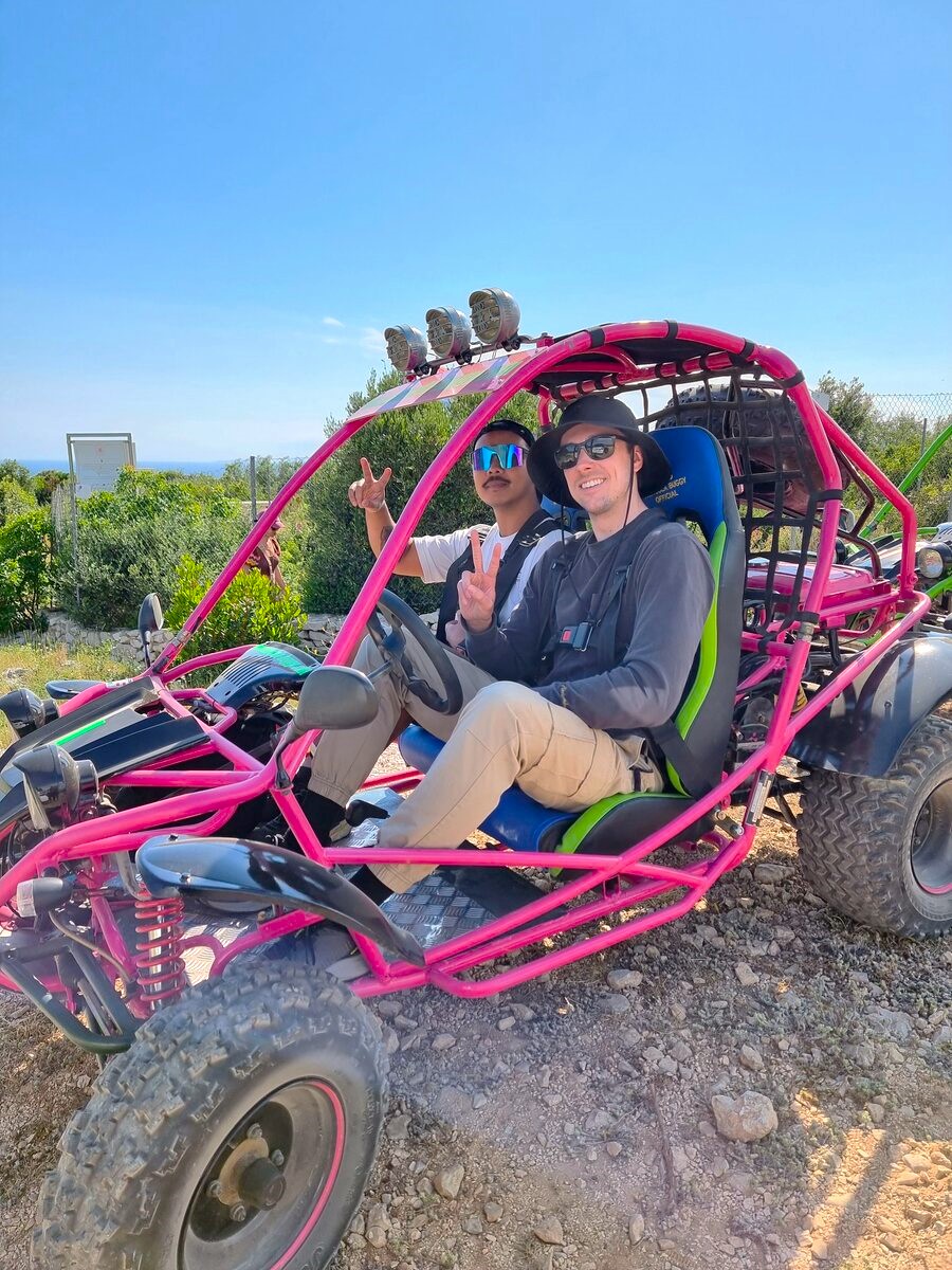 Image of two adults and a child riding a buggy in the foreground of the archipelago during a buggy tour on Korčula Island from Korcula Buggy (Official).