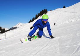 Un snowboardeur ride le long d'une piste pendant un Cours particulier de snowboard pour Tous niveaux & âges avec l'école de ski Diablerets Pure Trace.