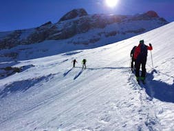 A group of skiers climb the snow-covered mountain with their Private Ski Touring Guide for All Levels from the Diablerets Pure Trace ski school.