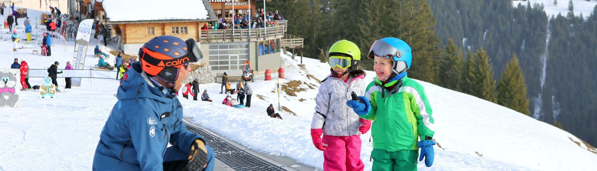 Children are practicing skiing on the practice area during their Kids Ski Lessons "SnowGarden" (3-4 y.) with the ski school Diablerets Pure Trace.
