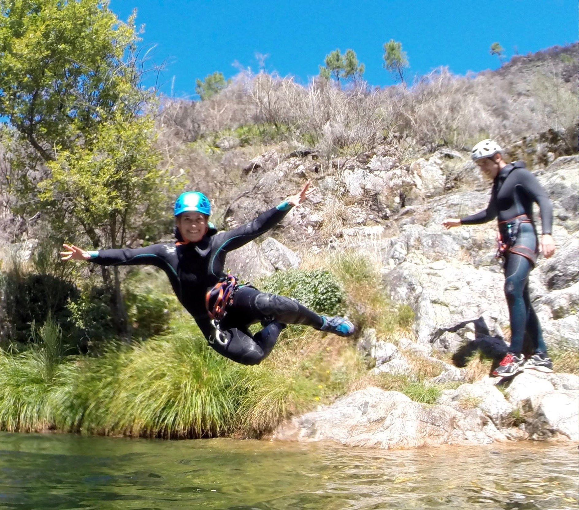 Woman jumping while doing Canyoning easy-moderate in Gerês National Park from WILDIT Tours Porto.