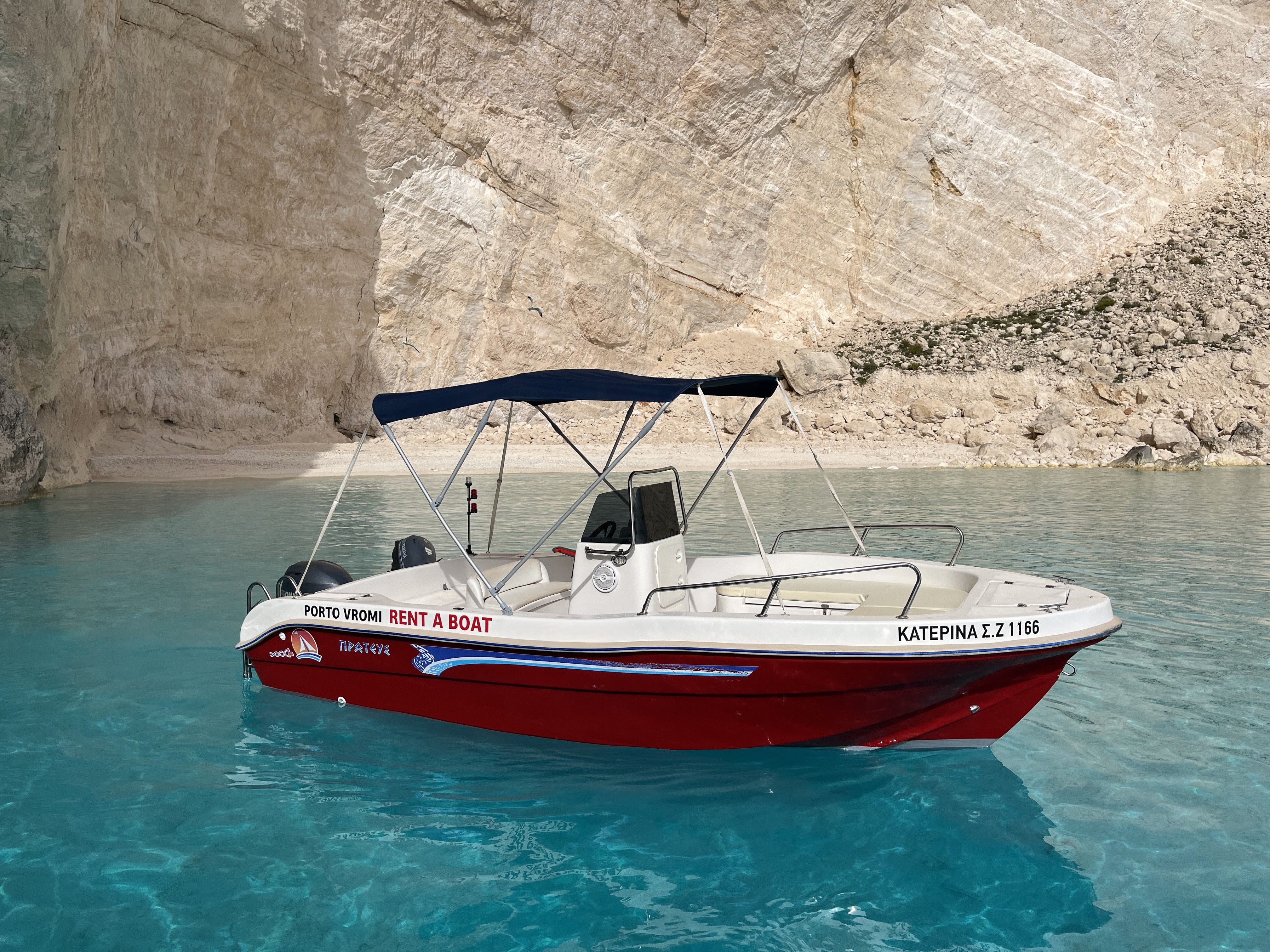 Boot zwemmen naar het helderblauwe water tijdens de privéboottocht naar Shipwreck Beach vanuit Porto Vromi met de schipper van Porto Vromi Boat Rentals.