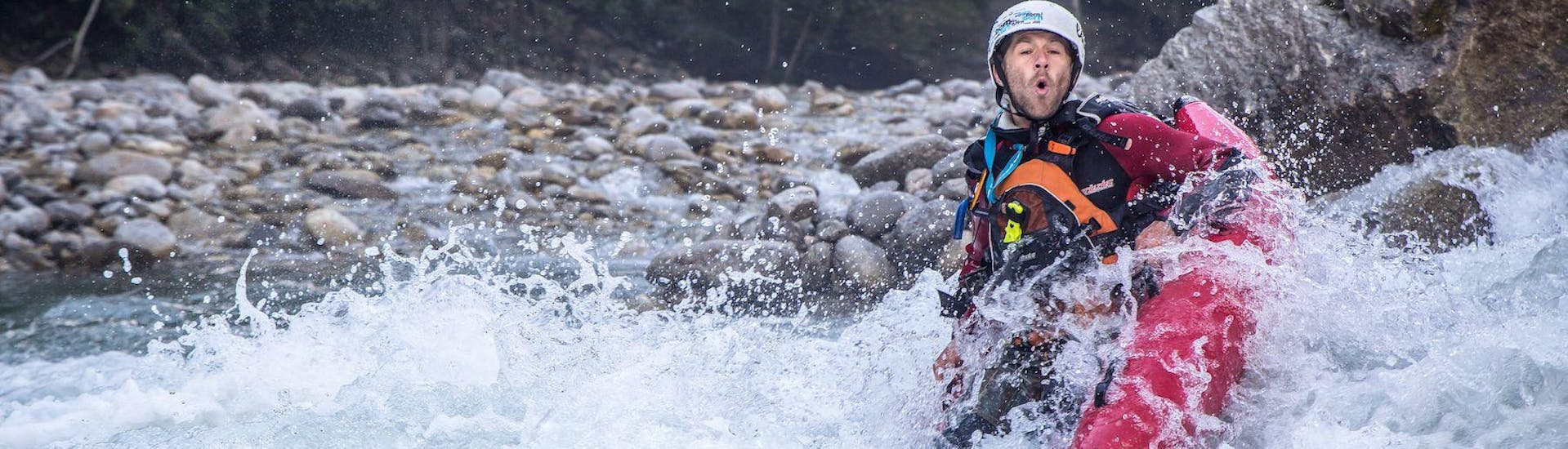 A participant of the tour River Bug for the Brave - Zemm with Mountain Sports Mayrhofen is trying to keep his tube steady in the rousing rapids of the river.