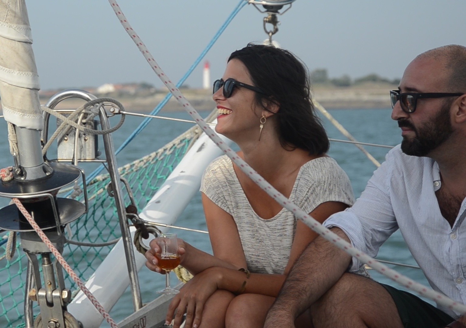 Mujer disfrutando de una copa de vino durante el Paseo en catamarán por Fort Boyard desde Boyardville con aperitivo con Île ou Aile Catamaran Oléron.