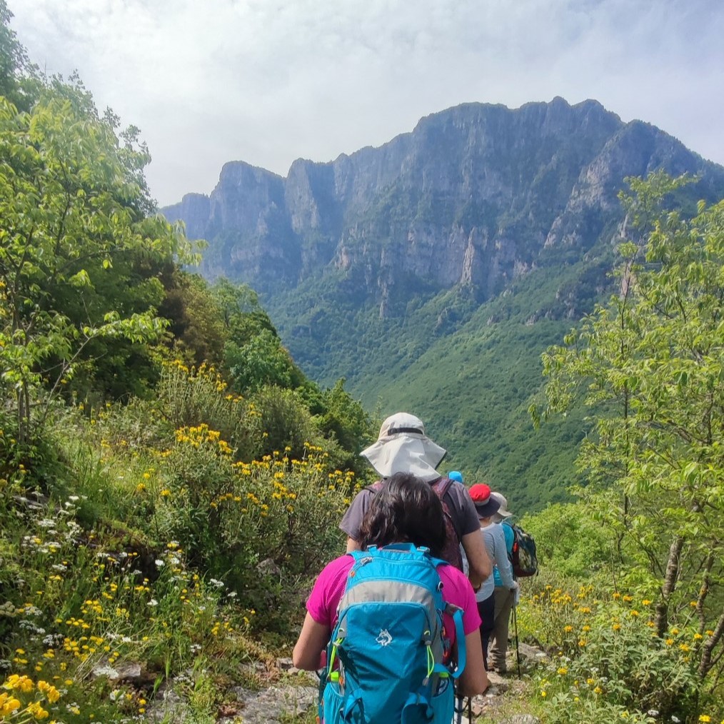 Des gens marchent sur un sentier de randonnée avec une vue panoramique sur les montagnes lors d'une randonnée à Kokkino Lithari depuis Papigo de Papigo Adrenaline.