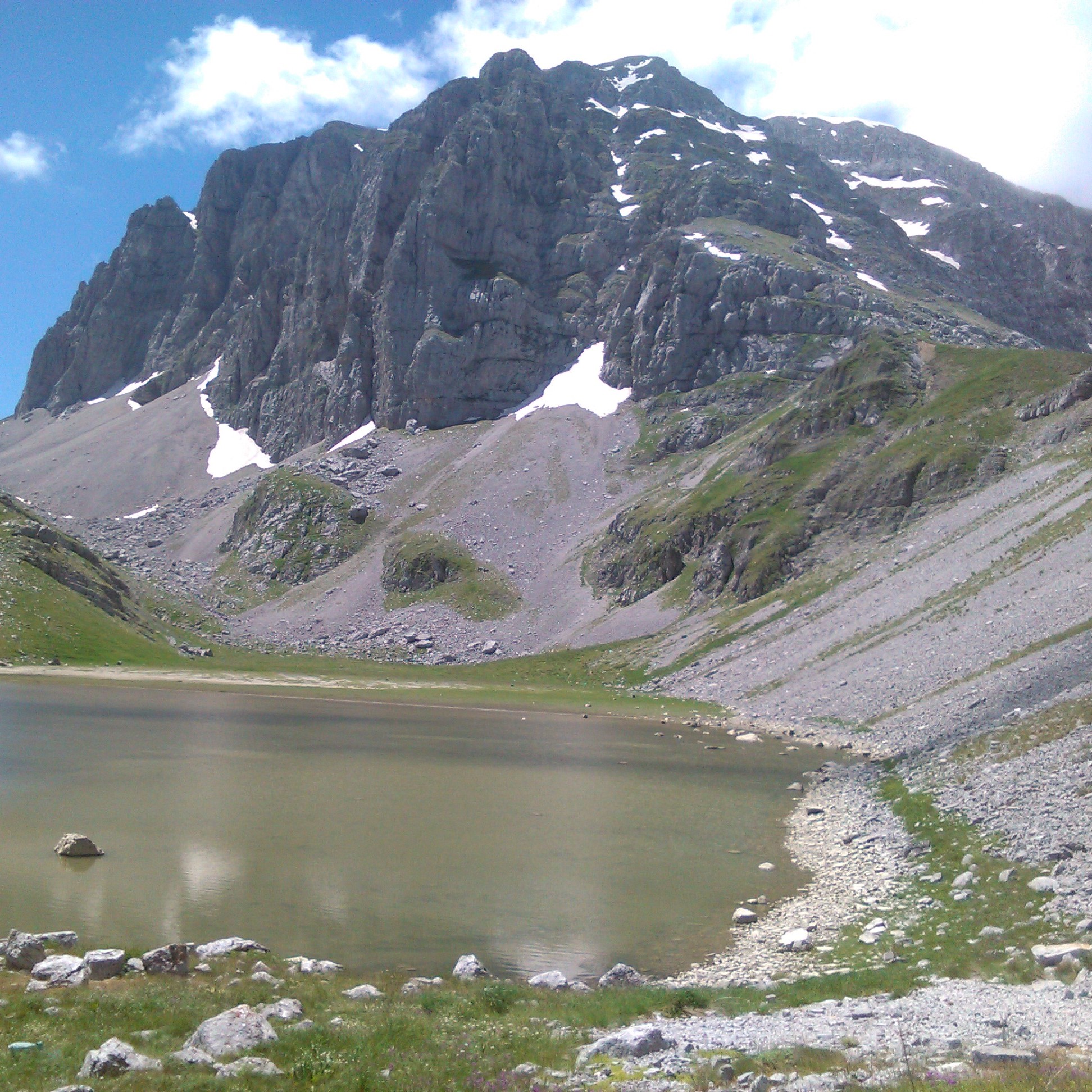 A lake in a valley in front of an impressive mountain during a Hiking Trip to Dragon Lake from Papigo from Papigo Adrenaline.