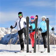 Un maestro di sci privato sorride all'obiettivo con due partecipanti alle lezioni private di sci per adulti - tutti i livelli organizzate dalla scuola di sci Ski- und Snowboardschule SNOWLINES Sölden nella stazione sciistica di Sölden.