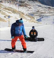 A snowboard instructor is teaching some triks to a participant of the Private Snowboarding Lessons for Adults organized by the ski school Ski- und Snowboardschule SNOWLINES Sölden in the ski resort of Sölden.