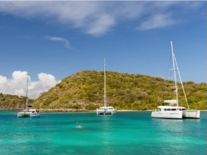 Three catamarans seen from a distance on the water during the Full Day Catamaran Trip to the Robert Islets with Lunch & Swimming.