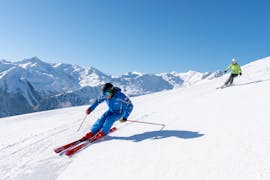 Zwei Skifahrer auf der Piste während ihres Privatunterrichts für Erwachsene aller Könnerstufen mit der Skischule Bad Hofgastein.