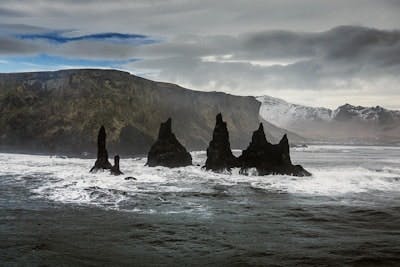 rcok columns in the sea with mountain landscapes in the background organized by GrayLine