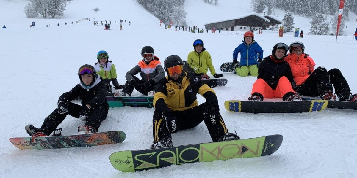 Snowboardkurs für Kinder & Erwachsene aller Levels mit Schi- & Snowboardschule Florian Kleinarl Eine Gruppe Snowboarder sitzt im Schnee während dem Snowboardkurs für Kinder & Erwachsene aller Levels mit Schi- & Snowboardschule Florian Kleinarl.