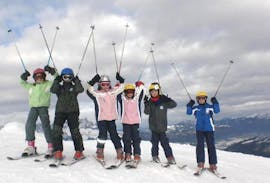 Un groupe d'enfants qui s'amusent au sommet de la montagne pendant les cours de ski pour enfants "Krokos Kids Club" (6-17 ans) pour tous les niveaux avec Skischule Alpin-Profis Kirchberg/Tirol.